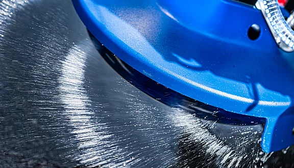Nahaufnahme eines rotierenden Fiedler Sole-Streutellers: Präzise und homogene Verteilung der flüssigen Salzlösung auf Asphalt zur effektiven Glatteisprävention im professionellen Winterdienst.